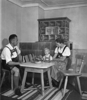 Junge Familie, auf einer Ofenbank sitzend