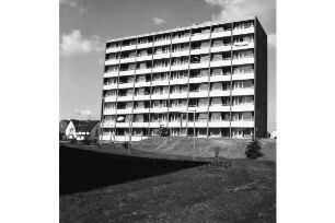 Hochhaus der Gemeinnützigen Wohnstättengenossenschaft eG Bad Oldesloe: davor Grünanlage: hinten links Einfamilienhäuser