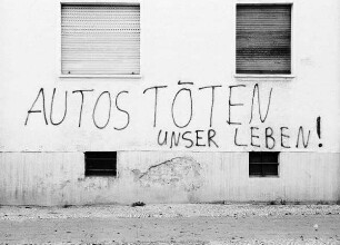 Fassade mit Inschrift "Autos töten unser Leben"