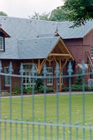 Gut: Schloßstraße 10: Nebengebäude [Konsulat] an Auffahrt zu Herrenhaus: Eingangsfront, Teilansicht: im Vordergrund Eisenzaun