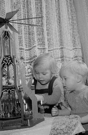 Zwei Kinder vor einer Weihnachtspyramide