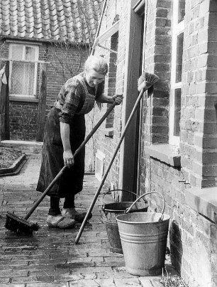 Petkum bei Emden. Eine Bäuern säubert am Wochende den Hof. Aufgenommen 1949