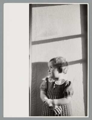 Portrait eines Kleinkindes durch ein Fenster blickend