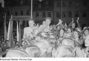 Eine Gruppe von Kindern sowie drei Erwachsene mit Blumensträußen in der Hand auf einer Bühne anläßlich des Tags der Republik