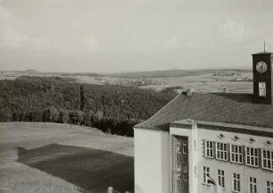 Rabenau (Sachsen), Schulstraße 6. Volks- und Berufsschule (1929; O. Hempel). Teilansicht vom Wasserturm nach Südosten mit Oelsa gegen Wilisch (478 m) und Luchberg (576 m)