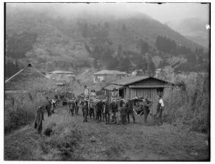 Hakone, ehem. Provinz Sagami, Japan. Touristen der HAPAG in Sänften. Blick gegen den Ort