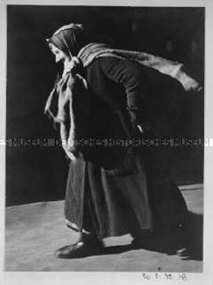 Alte Frau mit gesammeltem Brennmaterial