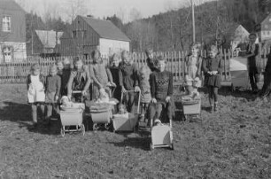 Kinder beim Spielen : Mädchen mit Puppenwagen und Spielzeugpuppen