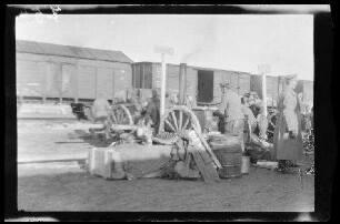 Soldaten, Wagenkarren und Material beim Beladen von Eisenbahnwaggons