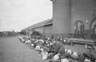 Zweiter Weltkrieg. Holland. Soldat in einer Reihe mit Marschgepäck auf einer Straße (vor der Abreise an die Front)