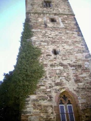 -Evangelische Kirche - Kirchturm von Westen mit Schießscharten (Schlitzscharten) sowie Werksteinen im Mauersteinverband