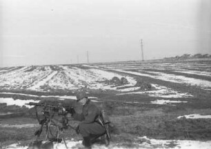 Wehrmachtsangehöriger an einem Maschinengewehr an einem Feld