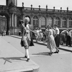 Fotografierte Fotografen. Als Lakai kostümierter Fotograf mit Kamerastativ im Zwingerhof in Dresden