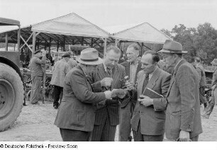 Gruppe während eines Interviews vor landwirtschaftlichen Geräten