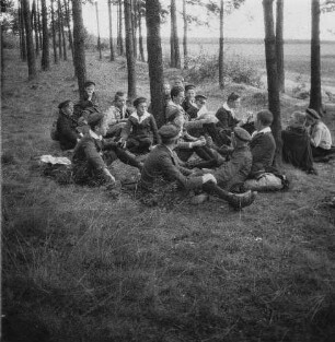 Schülergruppe mit Lehrer bei der Rast in einem Wald