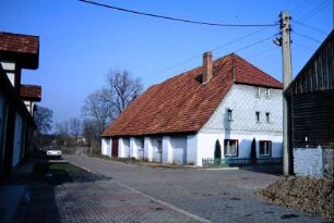 zum Wohnhaus umgebaute Gutsgebäude mit Krüppelwalm und tief gezogenem Dach
