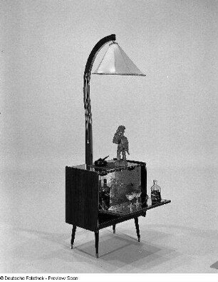 Stehlampe mit Hausbar : Leipzig. Leipziger Herbstmesse, 1983. Stehlampe mit Hausbar. Holz, folienbeschichtet in Makoréoptik, Kunststoff (1983; VEB Deutsche Piano-Union Leipzig, Betriebsteil Luckenwalde). Ansicht mit geöffneter Klappe