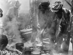 Männer beim Kochen : Hafenarbeiter kochen über offenem Feuer