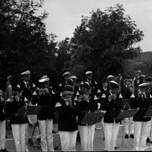 "Old Reinfelder Jungs e.V.": beim Musizieren in Aufstellung, mit Tambourmajor: auf Platz: hinten Büsche