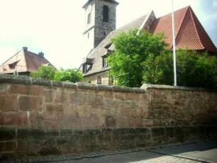 Ansicht von Südosten mit Kirche über Kirchhofmauer in unterschiedlichem Mauersteinverband (nach Süden Erneuerung nach Zerstörung im ersten Markgrafenkrieg)