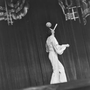 Auftritt eines Jongleurs in einem Varieté, der einen Ball auf den Kopf balanciert