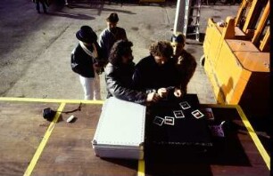 Conny Winter und sein Team beim Betrachten von Polaroidfotos bei Werbeaufnahmen für Müssig AG