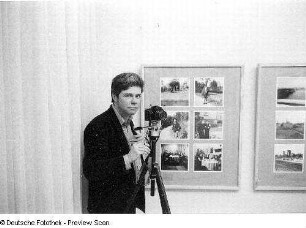 Christian Borchert mit Kamera in seiner Ausstellung anläßlich eines Ausstellungsgespräches, aufgenommen in Neubrandenburg