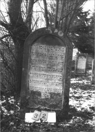 Grabstein 32 (Index: 99608716) Maße HxBxT: 114x57x10 cm Beschreibung: Stele mit Rundbogen, vertiefter Textteil: Grabstein 32