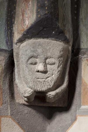 Spätromanische Konsolfiguren — Lächelnde Maske mit Ärmchen