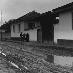 Drei Frauen im Gespräch vor einem Wohnhaus in Razhevo Konare. Die alte Handwerkskunst des Spinnens wird ausgeübt