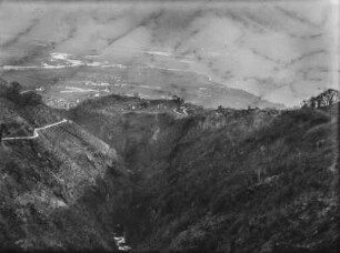 Berglandschaft : Blick über eine Berglandschaft. Im Tal ein See rechts, in der Mitte einzelne Siedlungen und landwirtschaftliche Nutzflächen