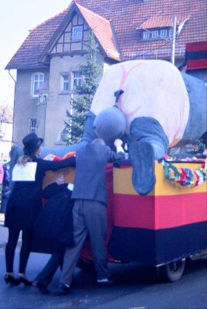 Umzug; Umzugswagen mit großem knieendem Elefanten von hinten