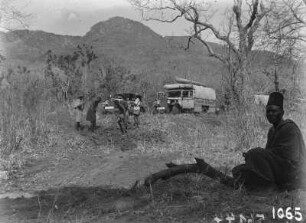 Im Busch : Savannenlandschaft mit Expeditionsteilnehmern und Lastwagen
