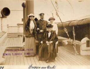 Nordlandreise, IV. Drei Damen und ein Herr in einem Gruppenbildnis neben den Rettungsbooten an Deck der Victoria Luise