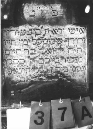 Grabstein 37 (Index: 99800316) Material: Sandstein Zustand: Sockel, der nicht zur aufgesetzten Stele gehört Beschreibung: getreppter Sockel, unten rusticaartig Besonderheit: wahrscheinlich gehört der Sockel zu der Stele Nr. 20A: Grabstein 37A