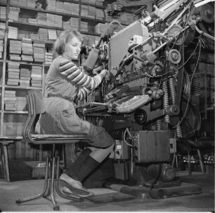 Arbeiterin an einer Setzmaschine, die hier für den Probelauf mit produzierten Matrizen eingesetzt wird : Dresden-Neustadt, Großenhainer Straße 9. VEB Typoart Dresden. Herstellung von Matrizen für eine Linotype-Setzmaschine. Arbeiterin an einer Setzmaschine, die hier für den Probelauf mit produzierten Matrizen eingesetzt wird