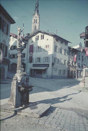 Bad Tölz. Straßenbild mit Floriansbrunnen. Blick zum Turm der Kalvarienkirche