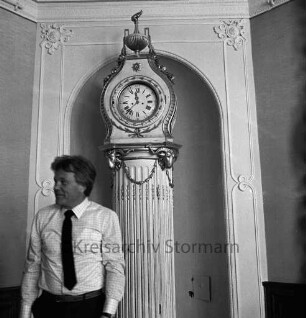 Besichtigung durch Landtagsabgeordnete der CDU: Festsaal: Kastellan Paul Hermann Buck vor Standuhr