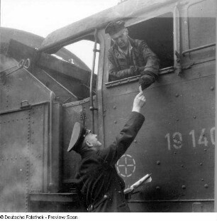 Zwei Eisenbahner an einer Dampflok (Teilansicht)