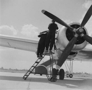 Leipzig-Mockau. Flughafen, Vorfeld. Zwei Techniker bei Wartungsarbeiten an einem Flugzeugmotor