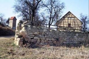 Natursteinmauer mit Scheune im Hintergrund, Trafohäuschen