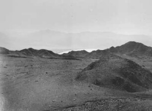 Wüstenlandschaft : Eine Wüstenlandschaft mit Blick auf eine Bergkette, die im Hintergrund silhouettenhaft zu erkennen ist. Im Hintergrund das Rote Meer