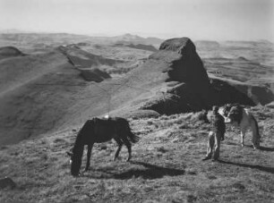 Die Drakensberge : Ein Mann und zwei Pferde vor einer markanten Felsformation in den Drakensbergen