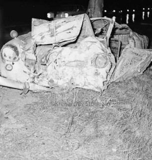 B 404: bei Herrenhaus Nütschau: Verkehrsunfall: Zusammenstoß von zwei Pkws und Auffahrunfall: am Straßenrand ausgebrannter Unfallwagen VW Karmann-Ghia nach Löschen: im Hintergrund Autoschlange mit Scheinwerfern, nasse Fahrbahn: im Dunkeln, 1. Mai 1967