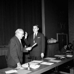 Manfred Samusch: Vereidigung: in Stadtverordnetenversammlung: mit erhobener Schwurhand: daneben Bürgervorsteher Kurt Nonne beim Verlesen des Eides: hinten rechts Personen, 4. Oktober 1966