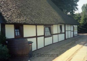 Schönningstedt: Königstraße 3: giebelständige Fachwerkkate mit Reetdach: nördliche Traufseite: nach Einsetzen neuer Fenster: hinten rechts Anbau