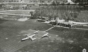 Flugplatz Dresden-Heller, Rollfeld mit Verkehrsflugzeug Junkers F-13 und zwei weiteren Flugzeugen vor dem Abfertigungsgebäude mit Kontrollturm, Luftbild-Schrägaufnahme