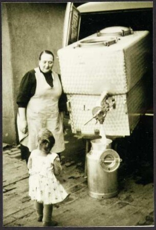 Frau mit Kind beim Abfüllen von Milch
