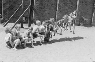 Betriebskindergarten der VEB Stralauer Glaswerke : Kinder auf einem Spielplatz auf einer Wippe