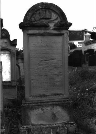 Grabstein 1155 (Index: 100104274) Material: Sandstein Zustand: stark verwittert mit erheblichem Textverlust Maße HxBxT: 194x63x23 cm Beschreibung: Stele auf getrepptem Sockel, überkragender Rundbogenaufsatz, im Bogenfeld aufgeschlagenes Buch, Schofar und Levitenkanne, unterster Sockel felsartig gearbeitet Symbolik: aufgeschlagenes Buch, Schofar, Levitenkanne Besonderheit: kulturhistorisch wertvoll / hist.-wiss. Gründe (Schofarbläser, Schächter u. Fleischbeschauer, Totengräber, Vorbeter ...): Grabstein 1155